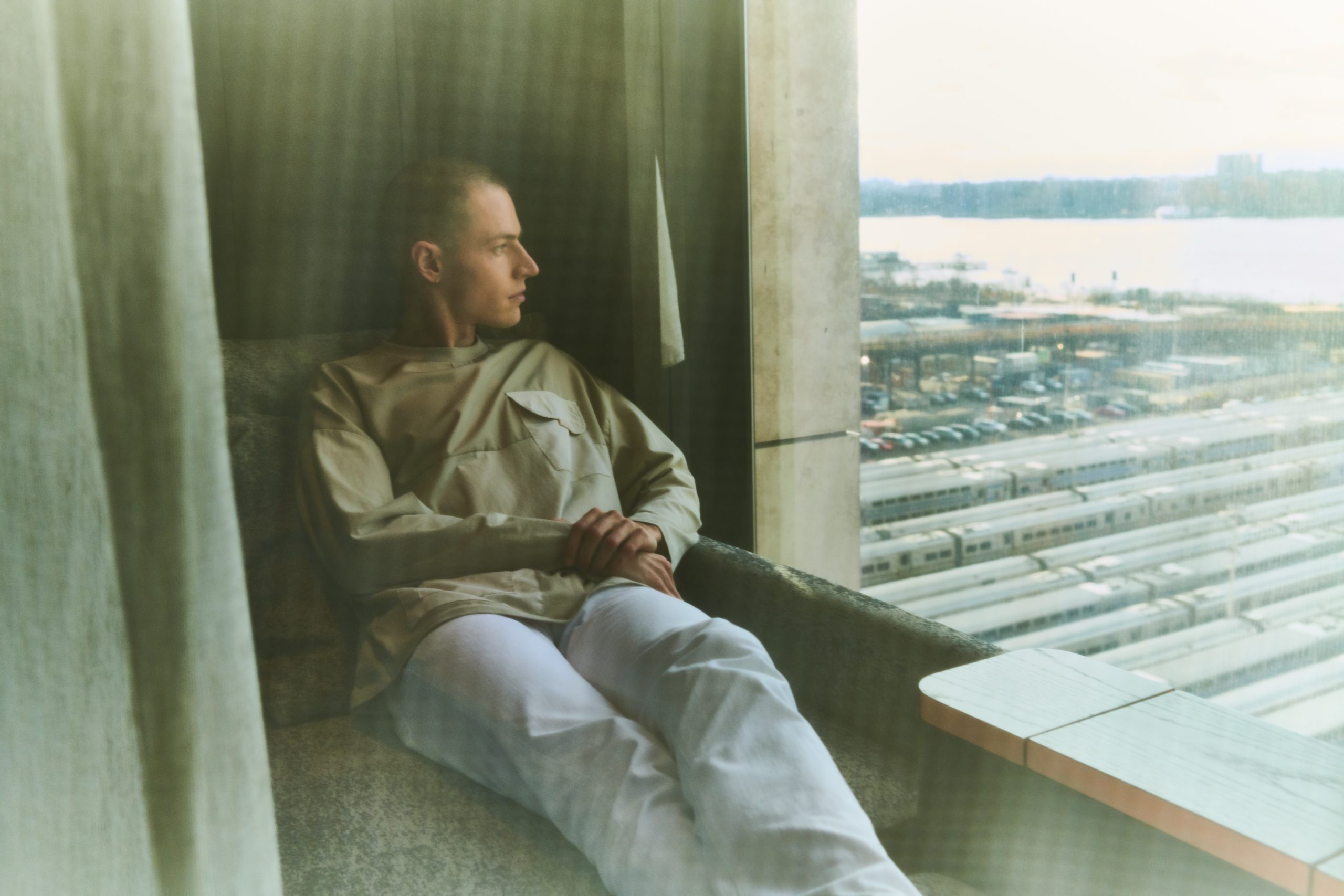 <man relaxing escape pod looking out of window onto hudson river