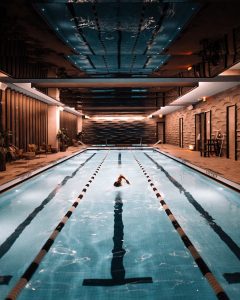 man swimming laps in indoor pool