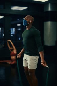 man jumping rope in mask in fitness center