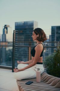 girl meditating on outdoor roof terrace