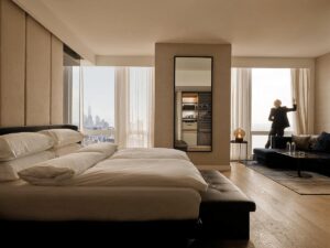 Bed in white sheets and views of Manhattan