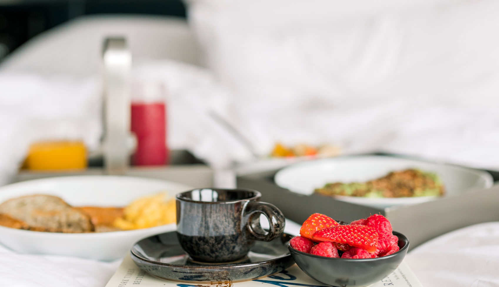 Breakfast in bed. Black cup with strawberries