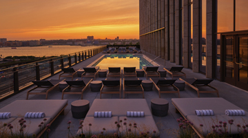 A terrace with pool and decks during the sunset