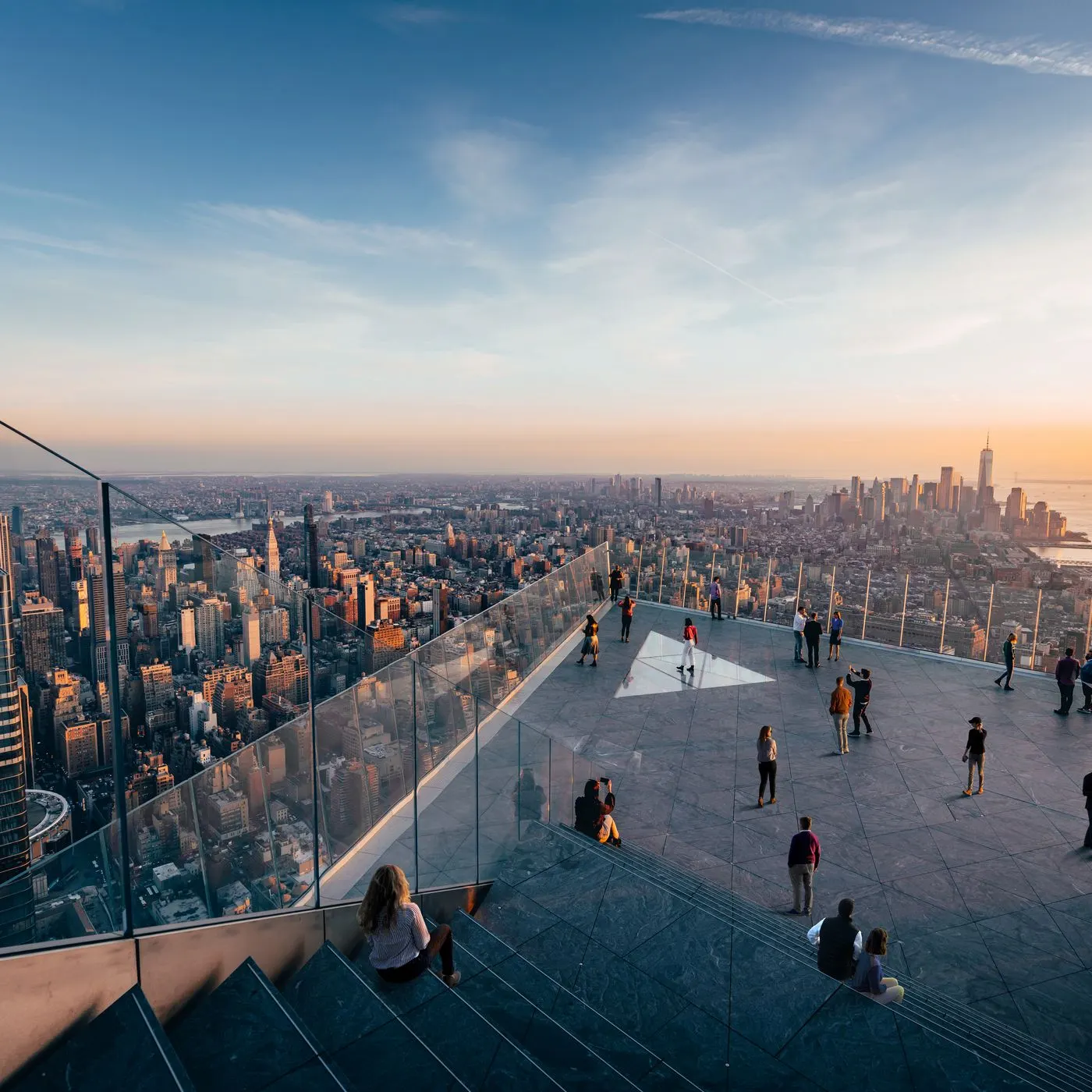 <Visitors on edge observation deck overlooking nyc skyline